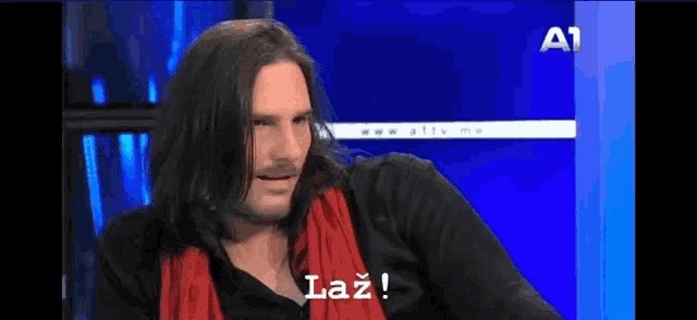 a man with long hair and a red scarf says laz on the screen