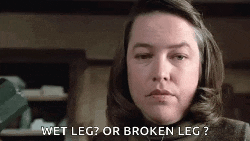 a woman is standing in a room with a broken leg and a wet leg .