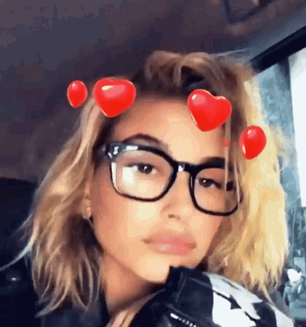 a woman wearing glasses with red hearts in her hair .