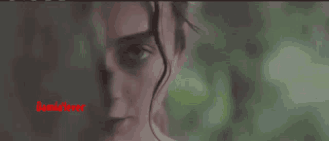 a close up of a woman 's face with a red watermark on the bottom of the image