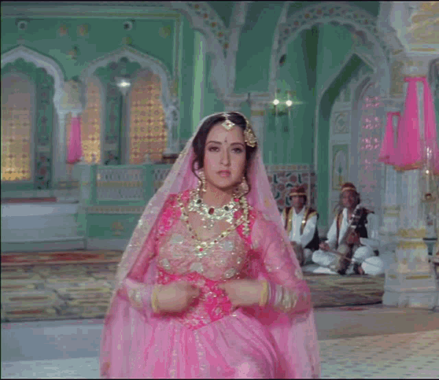 a woman in a pink and gold dress is dancing