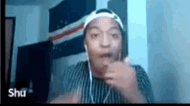 a man wearing headphones is pointing at the camera .