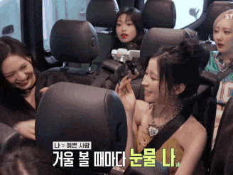 a group of women are sitting in the back seat of a car with korean writing on the side