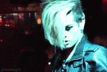 a woman with green hair is wearing a black jacket
