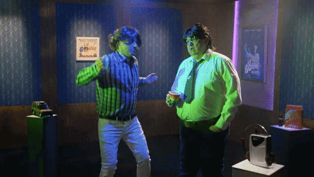 two men are dancing in a room with a sign on the wall that says ' bud light ' on it
