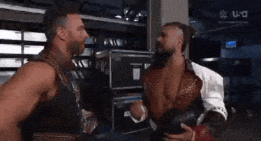 a couple of men are standing next to each other in a room .