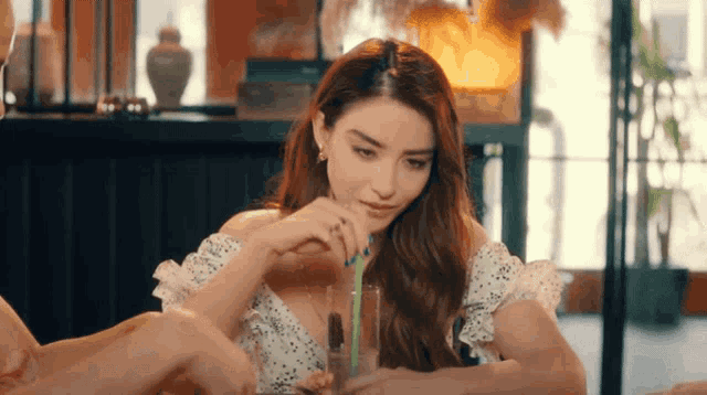 a woman is drinking through a straw in a restaurant
