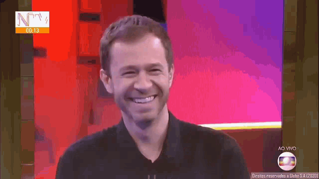 a man is smiling in front of a screen that says ntv on it