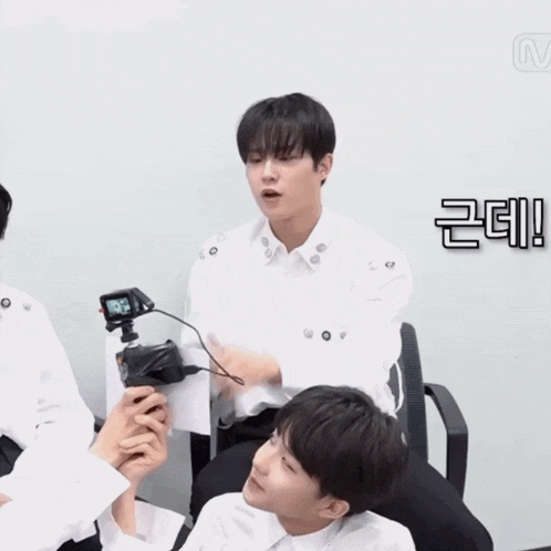 a man in a white shirt is sitting next to another man in a black shirt