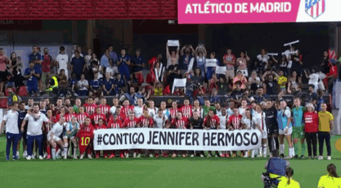 a group of soccer players holding a banner that says contigo jennifer hermoso