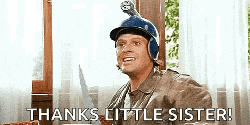 a man wearing a helmet with a hammer on top of it is sitting at a table with a saw .