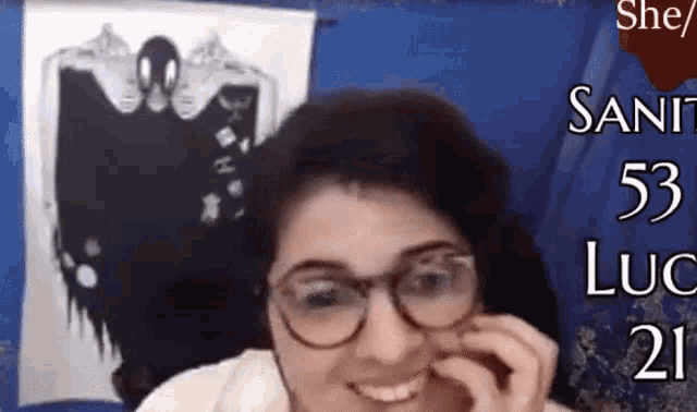 a woman wearing glasses is smiling in front of a banner that says she / sant 53 luc 21
