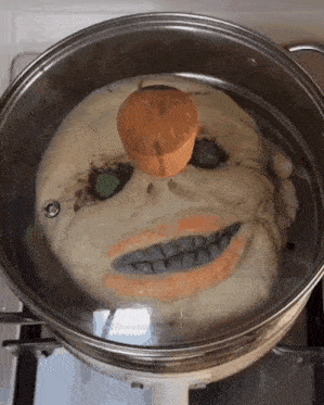 a pot of food with a face on it and a wooden lid