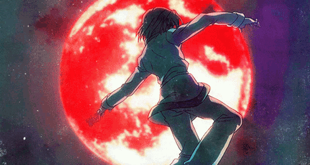 a person standing in front of a red moon
