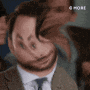 a man in a suit and tie is making a funny face with his hands .