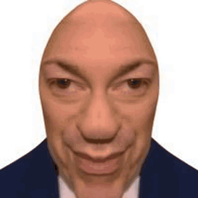 a close up of a man 's face with a bald head .