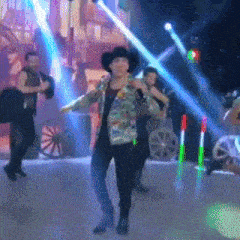 a man in a cowboy hat singing into a microphone on a stage