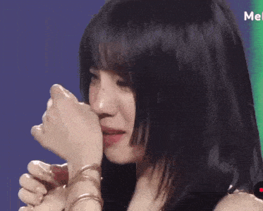 a close up of a woman covering her face with her hands