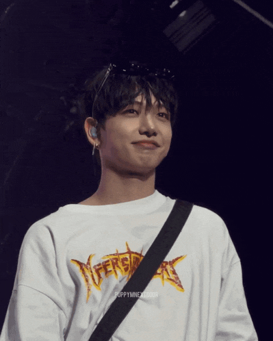 a young man wearing a white shirt that says versace on it