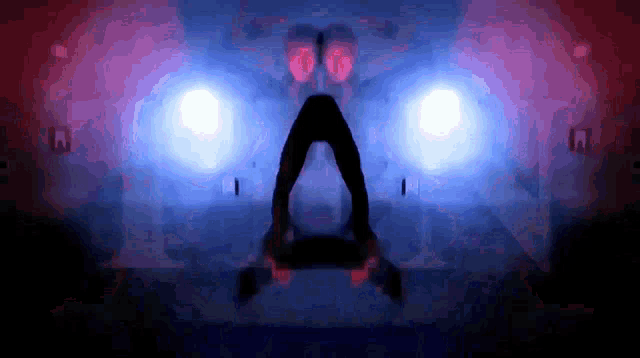 a silhouette of a person in a dark room with a red and blue light
