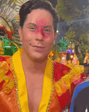 a man with red freckles on his face is wearing a yellow and red outfit