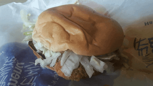 a close up of a chicken sandwich with lettuce on a bun