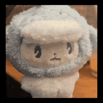 a stuffed animal that looks like a sheep wearing a hat