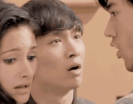 a man and a woman are standing next to each other and looking at each other with their mouths open .