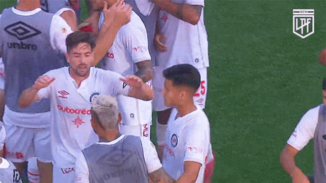 a group of soccer players wearing white jerseys with umbro on them