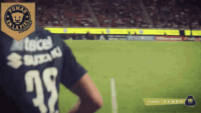 a player wearing a pumas jersey stands on a field