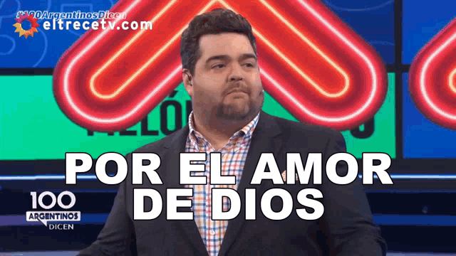 a man in a suit stands in front of a sign that says " por el amor de dios "