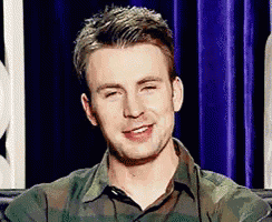 a close up of a man wearing a camouflage shirt smiling .