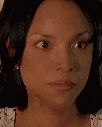 a close up of a woman 's face with her eyes closed and a serious look on her face .