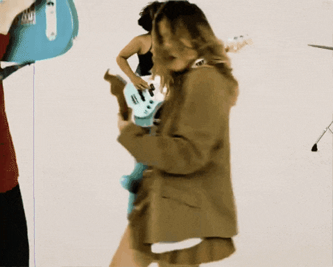 a woman playing a guitar next to a man playing a bass guitar