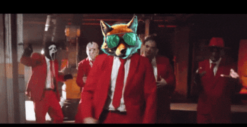 a group of men in red suits are dancing with a fox on their head