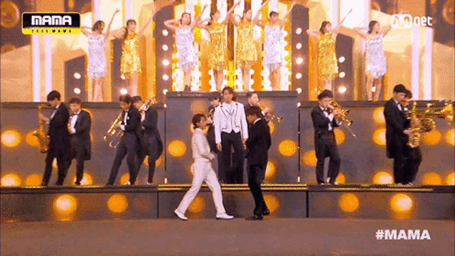 a group of people playing instruments on a stage that says mama on the top