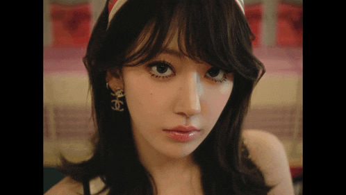 a close up of a woman wearing a headband and earrings with the letter s on them