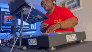 a man in a red shirt is playing music on a rave