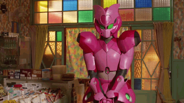 a pink robot with green eyes is standing in front of a stained glass window