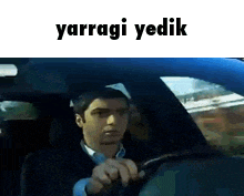 a man is driving a blue car with the words yarragi yedik above him
