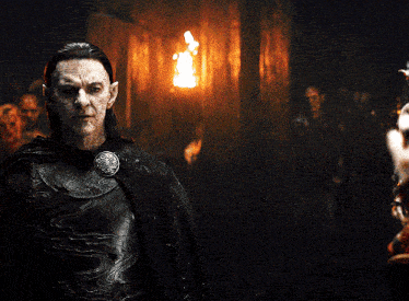 a man in armor stands in a dark room