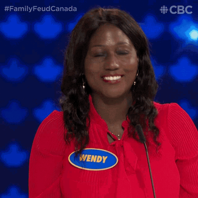 a woman in a red shirt has a name tag that says wendy on it