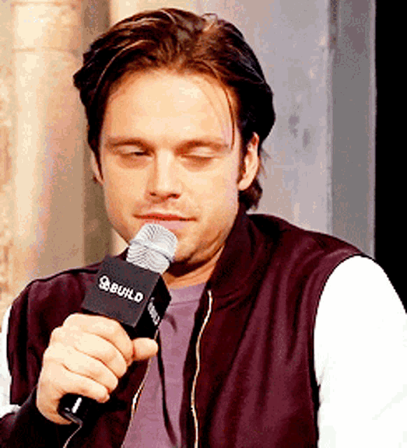 a man is holding a microphone that says build