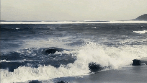 a large body of water with waves crashing on the beach