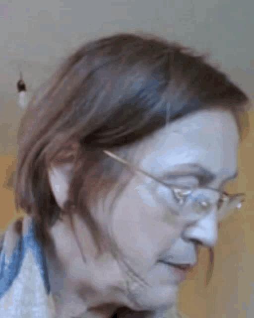 a close up of a woman wearing glasses looking down