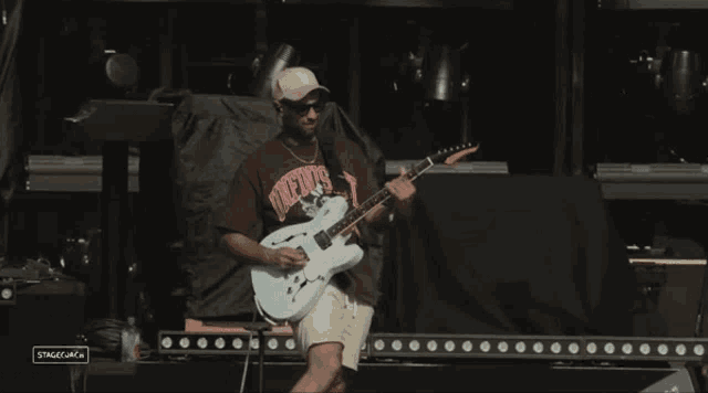 a man playing a guitar wearing a shirt that says natives on it