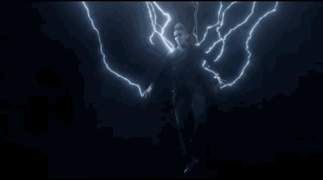 a man is surrounded by lightning strikes in a dark background