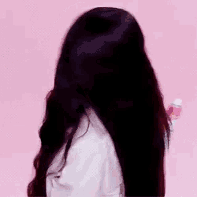 a woman with very long hair is holding a spray bottle .