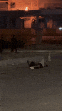a person laying on the ground in front of a building