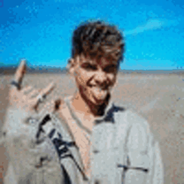 a young man is sticking his tongue out while making a rock sign .